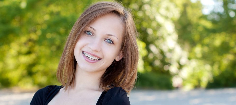 A smiling adolescent with braces representing the services of orthodontist Byrd Adkins D.D.S. Smile Company in Amarillo, TX