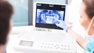 A dental professional showing an x-ray representing technology used by general dentistry office Byrd Adkins D.D.S. Smile Company in Amarillo, TX